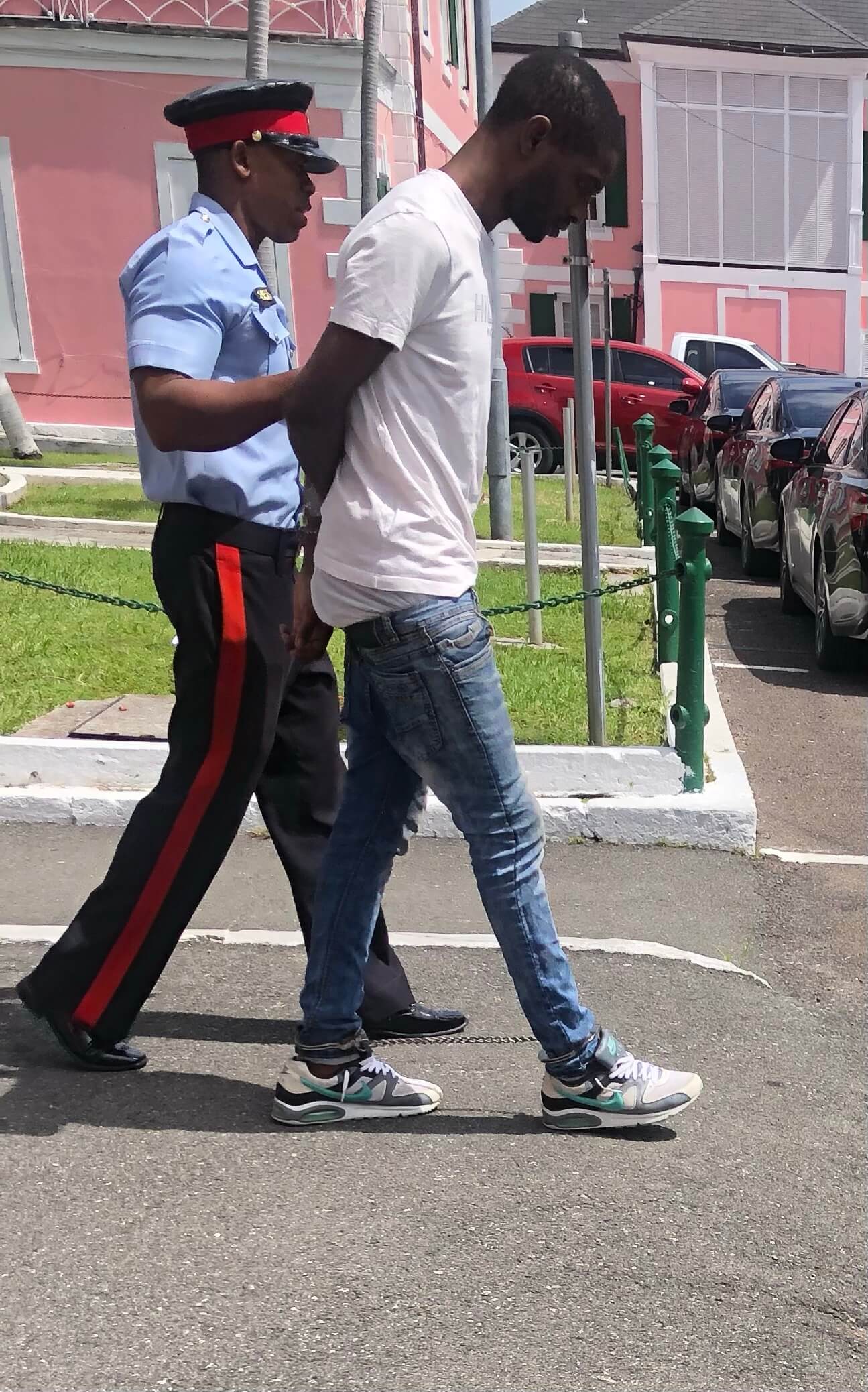 Convict Wayne Smith is escorted by a policeman